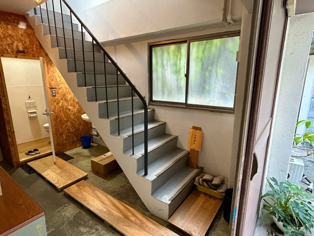 白ホリスタジオの建物1階。2階のスタジオへ上がる階段と、1階のお手洗い。ここから先は土足禁止